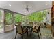 Relaxing screened porch with a ceiling fan and backyard views, furnished with a table and chairs at 9141 Covey Hollow Ct, Charlotte, NC 28210