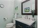 Charming powder room with blue vanity, white countertop, and decorative mirror at 9141 Covey Hollow Ct, Charlotte, NC 28210