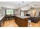 Open concept kitchen features a center island with stone countertop, hardwood floors, and views of the dining and living areas at 1005 8Th Sw Ave, Conover, NC 28613