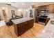 Open concept kitchen features a center island with stone countertop, stainless steel appliances, and hardwood floors at 1005 8Th Sw Ave, Conover, NC 28613
