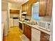 Functional kitchen with white appliances and wood cabinets, adjacent to laundry area at 1010 Macarthur Rd, Albemarle, NC 28001