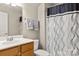 Cozy bathroom with a single sink vanity, toilet, and bathtub with a stylish, patterned shower curtain at 1031 Fants Grove Ln, Indian Land, SC 29707