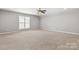 Expansive bonus room features neutral walls, plush carpet, and a ceiling fan for a bright and airy living space at 1031 Fants Grove Ln, Indian Land, SC 29707