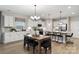 Bright kitchen with white cabinets, stainless steel appliances, and a dining area with seating for six at 1045 Mapletree Ln, Indian Trail, NC 28079