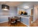 Cozy dining area featuring a modern light fixture and wood table adjacent to a functional kitchen at 10614 Hill Point Ct, Charlotte, NC 28262