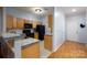 Bright kitchen featuring wood cabinets and black appliances, with a marble-top bar open to the dining area at 10614 Hill Point Ct, Charlotte, NC 28262
