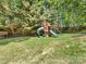 Beautiful backyard features a wooden playset with slide and swing and mature trees at 11126 Windgate Ct, Tega Cay, SC 29708