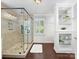 Bright bathroom featuring a glass enclosed shower, dark wood floors and white wainscotting at 11126 Windgate Ct, Tega Cay, SC 29708