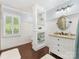 Bright bathroom featuring dark wood floors, a decorative shelving unit and a vanity at 11126 Windgate Ct, Tega Cay, SC 29708