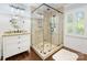 Bright bathroom featuring a glass enclosed shower, dark wood floors and a vanity at 11126 Windgate Ct, Tega Cay, SC 29708