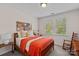 Comfortable bedroom with a wooden frame bed, colorful quilt, and rocking chair at 1209 Shelly Woods Dr, Indian Land, SC 29707