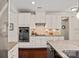 Well-lit kitchen featuring stainless steel oven, microwave, white cabinetry, and granite countertops at 1209 Shelly Woods Dr, Indian Land, SC 29707