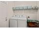 Bright laundry room with washer, dryer, and storage shelves and cabinets at 1209 Shelly Woods Dr, Indian Land, SC 29707