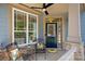 Inviting front porch with stylish seating, ceiling fan, and charming details at 1209 Shelly Woods Dr, Indian Land, SC 29707
