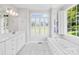 Bright bathroom featuring a soaking tub, double windows, and white cabinetry, perfect for relaxation at 132 Broadbill Dr, Mooresville, NC 28117