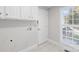 Functional laundry room with white cabinets, ample storage space, and a window for natural light at 132 Broadbill Dr, Mooresville, NC 28117