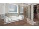 A luxurious bathroom features a large tub, a glass-enclosed shower, and a walk-in closet at 13339 Mcguffy Dr, Huntersville, NC 28078