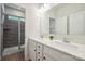Well-lit bathroom featuring a double sink vanity, white cabinets, and shower with gray tiling at 13339 Mcguffy Dr, Huntersville, NC 28078