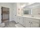 A bright bathroom featuring a double vanity, a walk-in closet, and modern fixtures at 13339 Mcguffy Dr, Huntersville, NC 28078