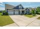 Well-maintained single-story home showcasing a spacious driveway, attached two-car garage, and a lush green lawn at 13339 Mcguffy Dr, Huntersville, NC 28078