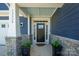 Close up of entryway, showing stone accents, house numbers, and well maintained landscaping in pots at 13339 Mcguffy Dr, Huntersville, NC 28078