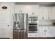 Modern kitchen featuring stainless steel appliances, white cabinets, and granite countertops at 13339 Mcguffy Dr, Huntersville, NC 28078