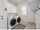 Convenient laundry room with modern washer and dryer, cabinets, and a bench seat at 13339 Mcguffy Dr, Huntersville, NC 28078
