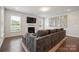 Cozy living room with a fireplace, large sofa, and an abundance of natural light at 13339 Mcguffy Dr, Huntersville, NC 28078