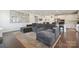 Open-concept living room featuring a plush sectional sofa, modern decor, and hardwood flooring adjacent to the kitchen at 13339 Mcguffy Dr, Huntersville, NC 28078