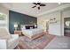 Main bedroom featuring a tray ceiling, a decorative wall, a ceiling fan, and an ensuite bathroom at 13339 Mcguffy Dr, Huntersville, NC 28078