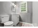 Bright bathroom featuring a modern vanity and toilet next to a window with natural light at 1510 Sansberry Rd, Charlotte, NC 28262