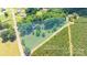 Aerial view of a residential property surrounded by lush greenery and adjacent to rows of evergreen trees at 155 Mcallister Rd, Statesville, NC 28625