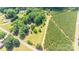 Aerial view of a residential property surrounded by lush greenery and adjacent to rows of evergreen trees at 155 Mcallister Rd, Statesville, NC 28625
