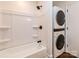 Full white bathroom including a tub and shower with a stacked washer and dryer at 155 Mcallister Rd, Statesville, NC 28625