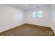 Bright bedroom features a window, neutral paint, plush carpeting, and a closet at 155 Mcallister Rd, Statesville, NC 28625