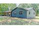 Side view of renovated one-story brick home featuring a metal roof, windows and manicured lawn at 155 Mcallister Rd, Statesville, NC 28625
