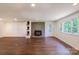 Bright living room with a brick fireplace, wood storage, and a large window for natural light at 155 Mcallister Rd, Statesville, NC 28625
