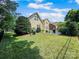 Spacious backyard with lush lawn, mature trees, and patio featuring seating and grill at 163 Shoreline Pkwy, Tega Cay, SC 29708