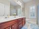 Bright bathroom featuring a double vanity, decorative mirror, and natural light from a window at 163 Shoreline Pkwy, Tega Cay, SC 29708