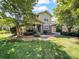Two-story home featuring a stone-accented facade, manicured lawn, and mature trees at 163 Shoreline Pkwy, Tega Cay, SC 29708