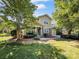 Welcoming home with a covered porch, stone detailing, and a two-car garage framed by shade trees at 163 Shoreline Pkwy, Tega Cay, SC 29708