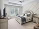 Cozy main bedroom with decorative wall, tray ceiling, and plush bedding at 163 Shoreline Pkwy, Tega Cay, SC 29708