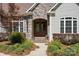 Close-up of the front entrance with a stone archway, double doors, manicured landscaping, and charming details at 1687 Sierra Rd, York, SC 29745