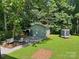 Green backyard with seating area and an outbuilding in the background at 201 Barnes Ln, Stony Point, NC 28678
