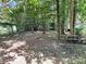 Natural backyard with picnic table and mature trees providing shade and a rustic outdoor space at 201 Barnes Ln, Stony Point, NC 28678