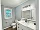 Bathroom featuring a large vanity with modern fixtures, toilet, and a window for natural light at 201 Barnes Ln, Stony Point, NC 28678