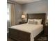 Bedroom featuring neutral walls, wood-look floors, and a large bed with a wooden headboard at 201 Barnes Ln, Stony Point, NC 28678