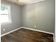 Bedroom featuring wood-look floors, gray walls, white trim, and a window for natural light at 201 Barnes Ln, Stony Point, NC 28678