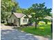 Quaint home nestled among mature trees featuring gravel driveway, tidy lawn, and lovely front porch sitting area at 201 Barnes Ln, Stony Point, NC 28678