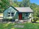 Alluring one-story home with bright front door, complemented by lush landscaping and a cozy porch area with seating at 201 Barnes Ln, Stony Point, NC 28678
